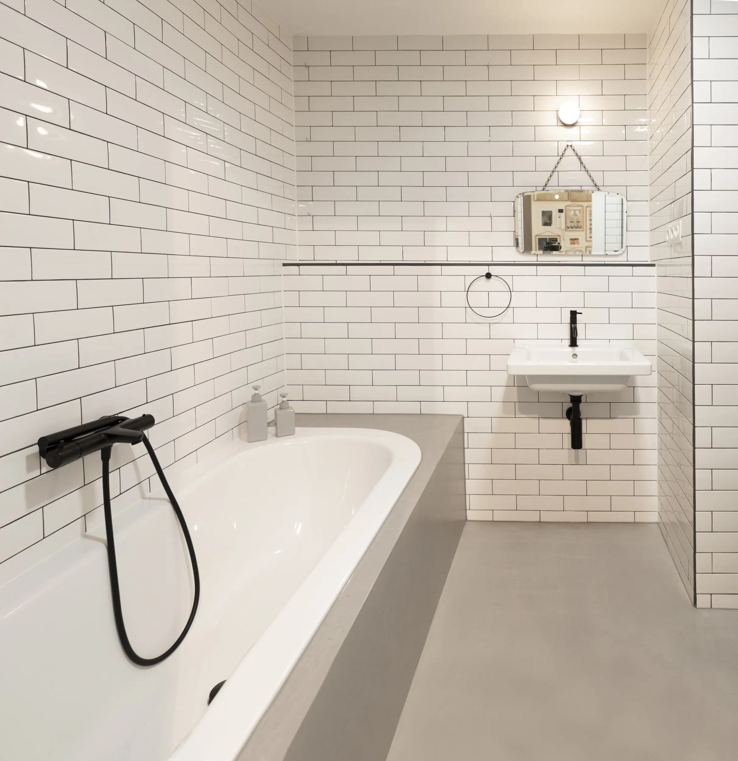 Bathroom with microcement floor and metro tiles. Bathroom renovation Amsterdam